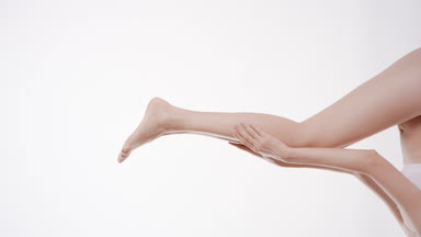 Slim woman touches her smooth moving leg