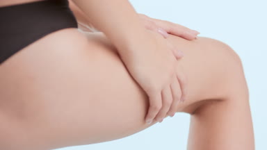 Good-looking slim woman in black underwear strokes smooth hip