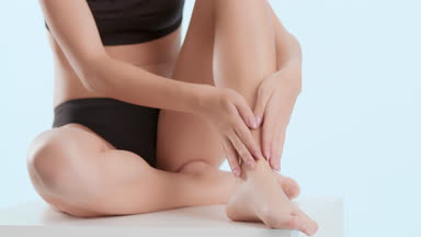 Woman strokes leg sitting on platform and puts head on knee
