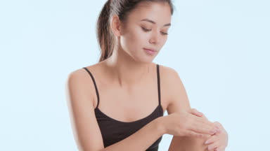 Woman in black top touches leg sitting and puts head on knee