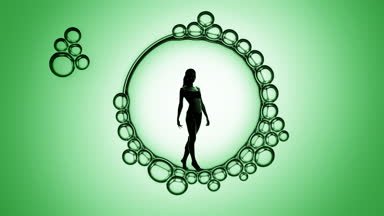 Woman's silhouette inside macro soap bubbles on green background