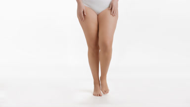 Plus size model in white underwear goes to the camera on tiptoes