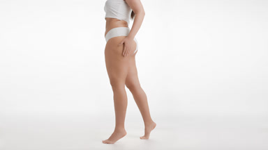 Plus size female model stands sideways and puts hand on waist