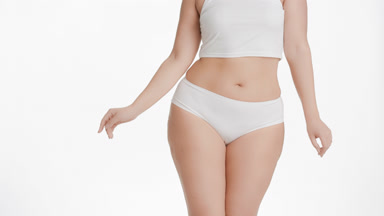Plus size woman in white underwear moves her hips dancing