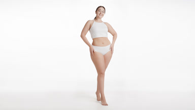 Young Caucasian cute plus size woman strokes body smiling wide