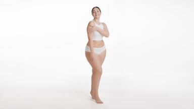 Caucasian plus size woman strokes hand and clavicles smiling