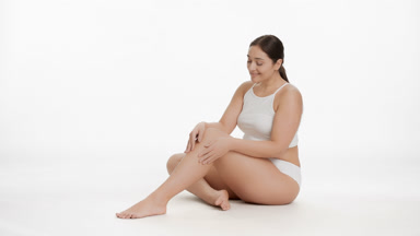 Caucasian plus size woman in white underwear strokes leg smiling