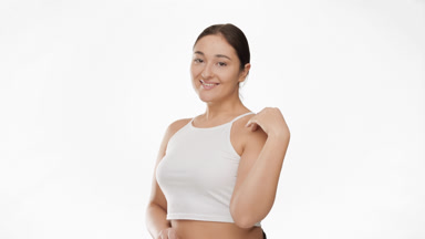Pretty plus size woman in white top strokes clavicles smiling
