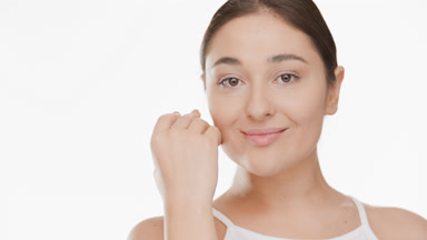 Caucasian young plus size brunette woman strokes face smiling