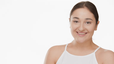 Laughing attractive plus size woman in white top turns head