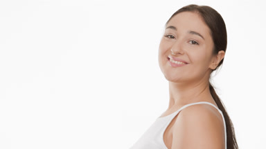 Gorgeous plus size woman in white top turns to camera smiling