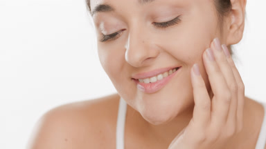 Young cute Caucasian brown-haired woman strokes face smiling