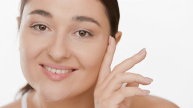 Attractive woman with long dark hair strokes jaw line smiling