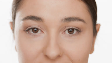 Good-looking Caucasian woman with dark hair blinks occasionally