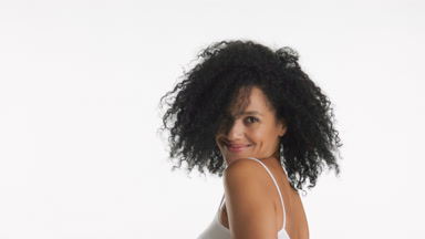 African American woman moves head and touches curly black hair