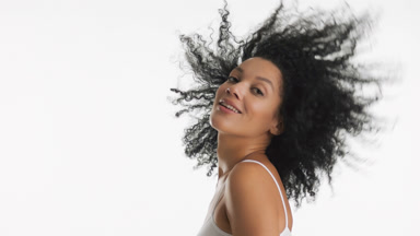 African American young woman with curly dark hair moves head up