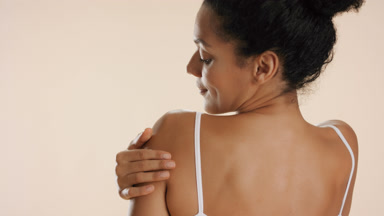 Beautiful slim African American woman strokes shoulder and arm