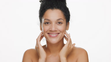 Attractive young slim African woman strokes face smiling wide