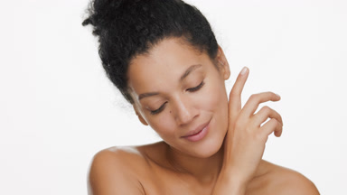 Young gorgeous African American woman strokes jaw line smiling