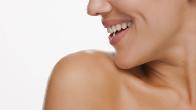 Good-looking slim female model moves shoulder to chin smiling