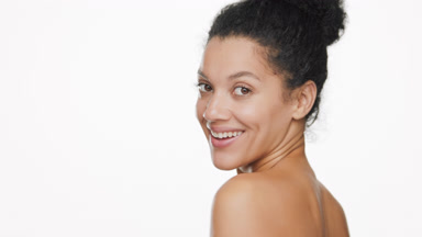 African woman smiles for camera and turns going away from it