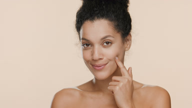 Gorgeous African American woman presses her cheek and smiles