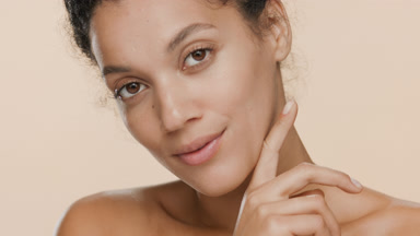 Good-looking African American woman strokes jaw line and smiles