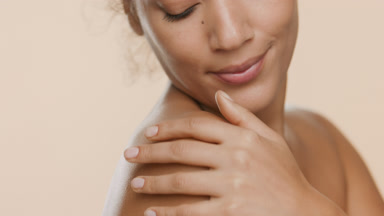 Attractive African woman with bare shoulder strokes it smiling