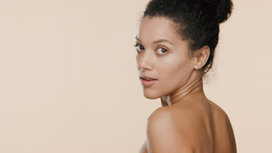 African dark-haired woman with bun hairstyle turns going away