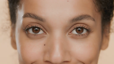 Brunette African young woman with curly hair blinks occasionally