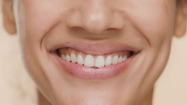 Extreme close-up of female model smiles wide for the camera
