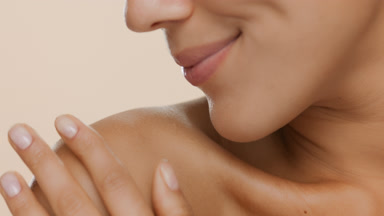 Extreme close-up of good-looking woman strokes shoulder smiling
