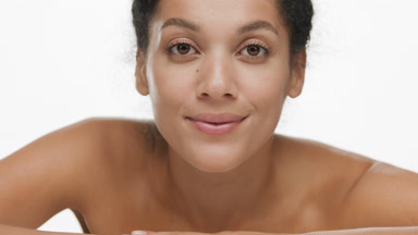 Gorgeous young African American woman put head on hands smiling
