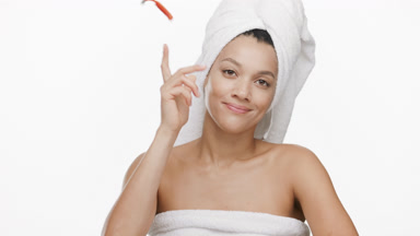 Funny African woman with towel on hair throws away orange razor