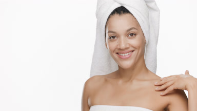 Beautiful African woman with a towel on head stokes clavicles