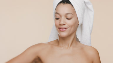 African woman raises arm and stokes it and armpit smiling wide