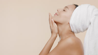 African young woman with a towel on head stokes neck enjoying it