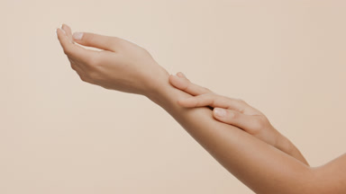 Close-up shot of female skin care model strokes hand and forearm