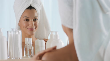 Slim African woman strokes body and face in front of the mirror
