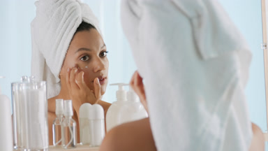 Young woman strokes cheek and decides to apply cream on another