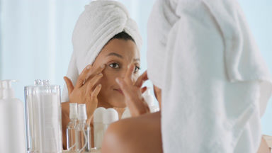 African woman touches face and disappoints in front of mirror