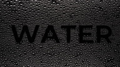 Water inscription blown off the wet glass on black background