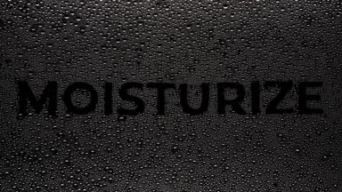 Moisturize text blown off the wet glass on black background