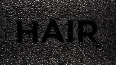 Hair text blown off the wet glass on black background