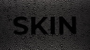 Skin word blown off the wet glass on black background