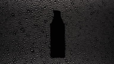 Serum bottle shape print blown off the wet glass on black bg