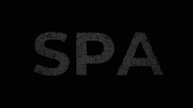 Spa inscription blown off the wet glass on black background