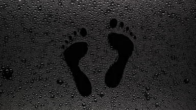 Footprints blown off the wet glass on black background