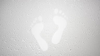 Footprints blown off the wet glass on grey background