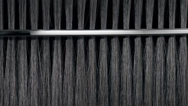 Black hair being combed with silver comb